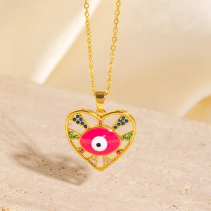 Detail of gold heart pendant featuring a pink evil eye motif with colorful crystals