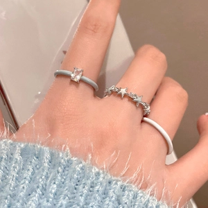 Detail of stacked zircon rings featuring a square crystal, stars, and blue enamel bands