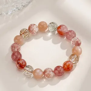 Close-up of strawberry quartz and sunstone beaded bracelet with natural mineral textures