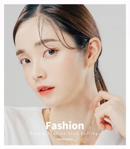 Close-up detail of elegant gold-plated butterfly stud earrings worn by a model