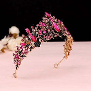 Macro view of gold bridal crown featuring pink marquise rhinestones and black floral motifs