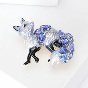 Detailed close-up of a silver fox brooch with blue enamel and sparkling rhinestones