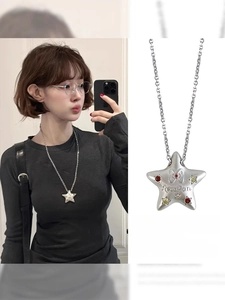 Gros plan du pendentif étoile argenté avec zircons colorés et détails de gravure