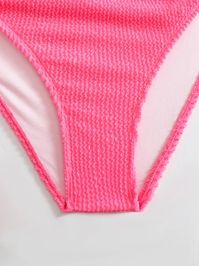 Detailed close-up of bright pink bikini bottom with textured seersucker fabric and lining