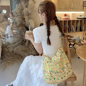 Detail showing high-capacity floral tote bag with yellow tulip pattern on a model
