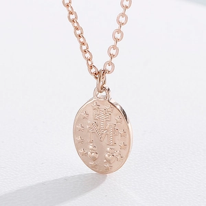 Close-up of rose gold Miraculous Medal pendant with engraved religious cross and star details