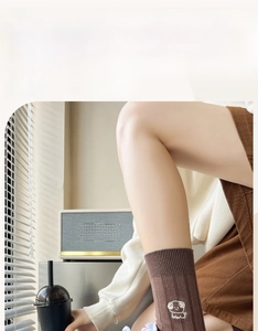 Close-up of dark brown cotton socks featuring white cartoon puppy embroidery details