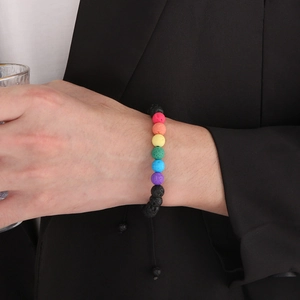 Dettaglio del braccialetto con perline in pietra lavica arcobaleno sul polso