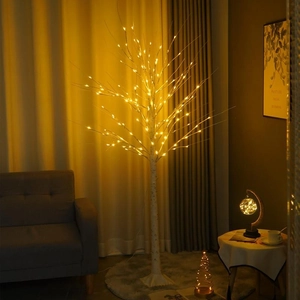 Close-up of warm white LED birch tree lamp with realistic bark texture in a cozy living room