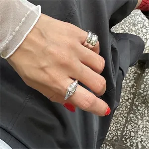 Detail of minimalist 925 sterling silver irregular ring and wide double-band ring