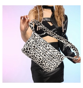 Sac bandoulière tendance à motif léopard avec trois poches zippées sur modèle