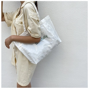 Detail of transparent PVC tote bag with white canvas lining and green Skillfully print