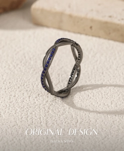 Macro detail of black crisscross S925 silver ring with pavé blue zircon stones