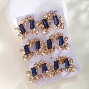 Detailed view of butterfly-themed gold-plated ear cuffs with blue rectangular zircons