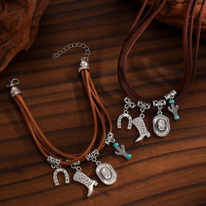 Detail of Western-style braided jewelry featuring silver boot, hat, and cactus charms