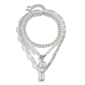 Detail of layered silver chain necklace with baroque pearls, coin and lock pendants