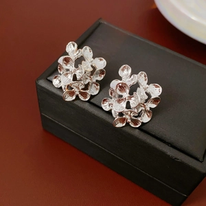 Detailed view of silver flower stud earrings on a premium black velvet jewelry box