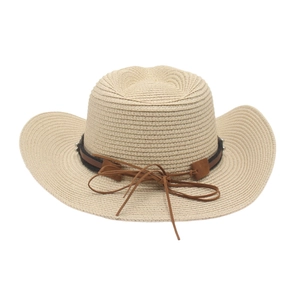 Close-up of hand-woven raffia straw cowboy hat with brown leather band and metallic studs