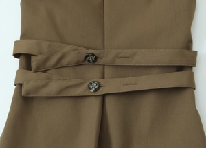 Detailed view of the double-breasted back adjustment strap on khaki sleeveless top