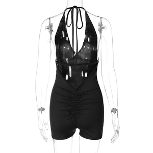 Front view of sexy black halter neck romper with backless pleated details on model
