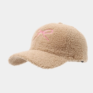 Detail of khaki sherpa baseball cap featuring pink bow embroidery and fuzzy texture