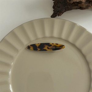 Detail of tortoise shell hair claw with France Handmade inscription on ceramic plate