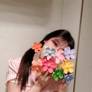Close-up of matte flower hair claws for girls in various pastel colors and floral shapes