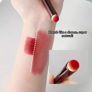 Detail of round smudge brush blending dark pigments smoothly onto skin for seamless look