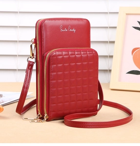 Detail of red dual-layer crossbody bag featuring quilted front pocket and gold hardware