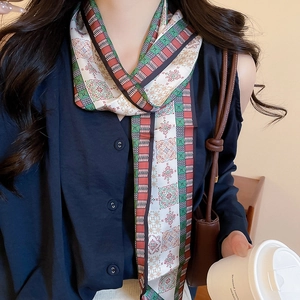 Detailed close-up of retro paisley print silk scarf necklace in red green and white