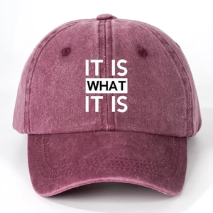 Detail of burgundy washed cotton baseball cap with white IT IS WHAT IT IS printed text