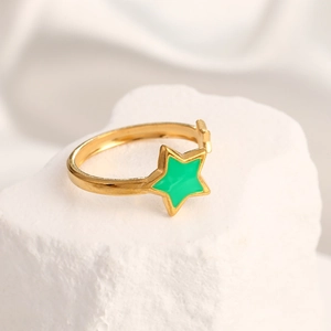 Close-up of golden adjustable ring featuring a vibrant green enamel star on stone