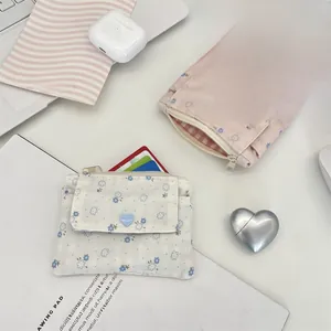 Gros plan de porte-monnaie en tissu floral avec bouton coeur et fermeture zippée