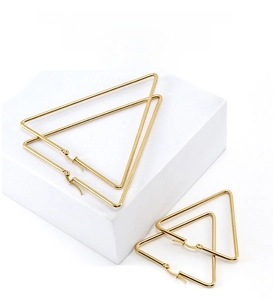 Détail de boucles d'oreilles triangulaires dorées 18K de tailles variées sur supports