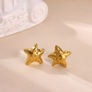 Elegant gold starfish stud earrings with pearl and zircon on beige silk background