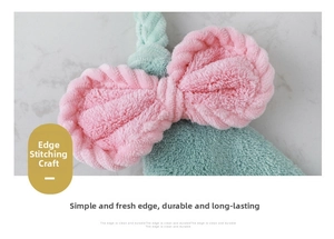 Close-up of pink coral fleece bow headband with neat edge piping on marble surface