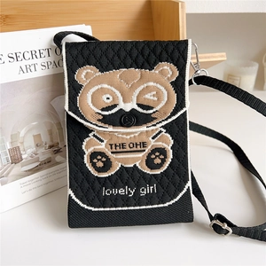 Detail of knitted bear crossbody bag featuring textured fabric and adjustable strap