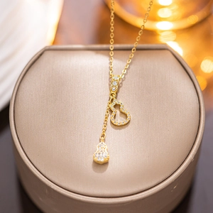 Exquisite golden necklace with sparkling micro-pave gourd pendant on an elegant stand