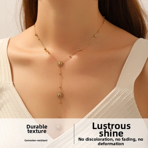 Detailed view of elegant gold-toned Y-shaped necklace with sun flower diamond pendants