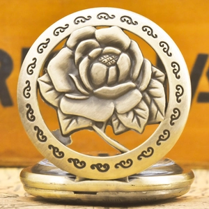 Close-up of vintage bronze pocket watch featuring an intricate hollow rose carved cover