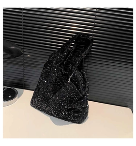 Detail of a sparkling black sequin tote bag with matching coin purse on a sleek white surface