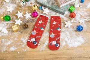 Detail of red Christmas socks with cute cartoon animal patterns and white fuzzy trim