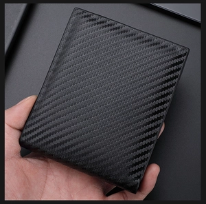 Close-up of a men's black carbon fiber texture wallet with minimalist bifold design