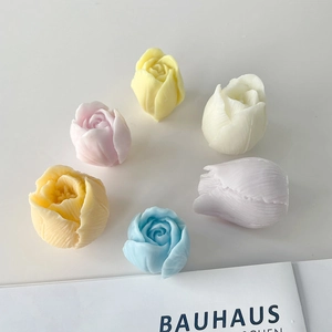 Macro detail of tulip and rose shaped scented candles in various pastel colors
