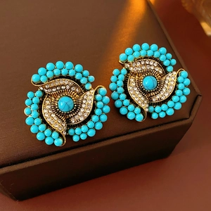 Detailed view of vintage flower earrings with turquoise beads and white rhinestones