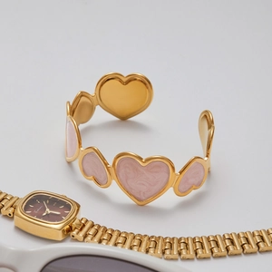 Detail view of 18K gold-plated heart bracelet with pink marble enamel inlay