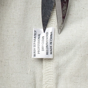 Detailansicht des Pflegeetiketts auf dem Leinenmischgewebe von Weste und Hose Set