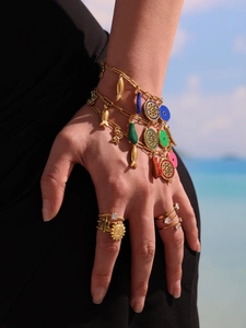 Dopamine enamel multi-layer bracelets and rings on a model at a sunny beach resort
