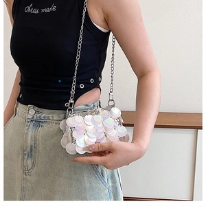 Detail of silver sequin mini bag showing the shimmering circular disc chain strap design