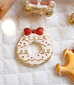 Detail of Christmas wreath ornament with red glitter bow and gold spiral accents